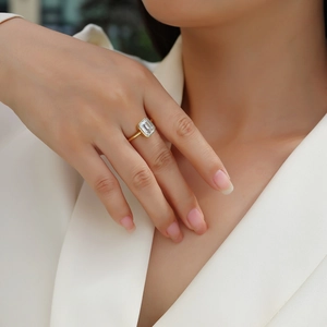 Détail de la bague moissanite taille émeraude avec serti clos doré sur un modèle