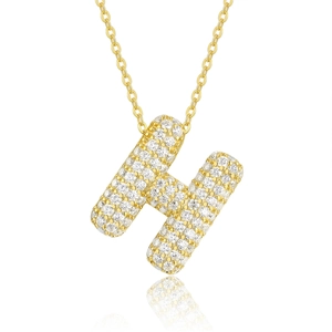 Macro detail of 925 silver 18K gold letter H pendant with pavé setting moissanite