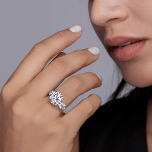 Elegant S925 sterling silver three-stone moissanite ring worn on hand with side accents