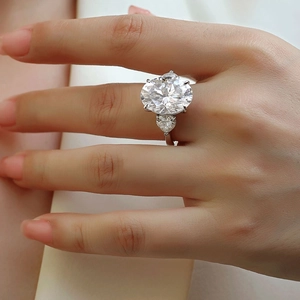 Primo piano di un anello a tre pietre di lusso con pietra ovale e diamanti a goccia
