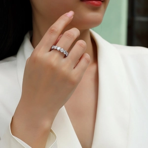 S925 sterling silver band ring with five round moissanite stones on a female hand