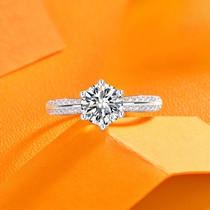 Makroaufnahme eines klassischen Sechs-Krallen-Diamantrings auf lebhaftem orangefarbenem Hintergrund
