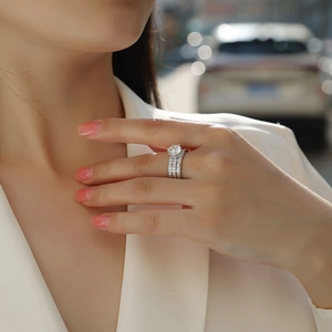 Detail of three-piece S925 silver moissanite ring set worn in a natural light setting