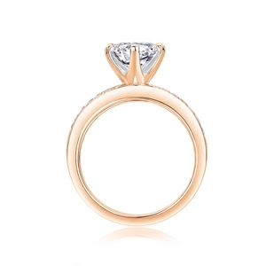 Close-up of rose gold ring featuring a six-prong set round moissanite and side stones