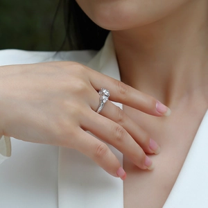 Close-up of a S925 silver engagement ring with a round lab diamond on a model's hand