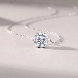 Detailed close-up of a brilliant round cut moissanite pendant with six-prong setting