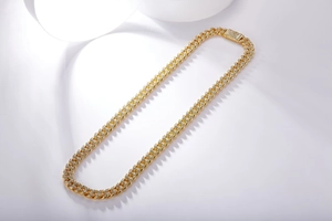 Close-up of gold Cuban link chain necklace with sparkling moissanite stones and pave clasp