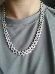 Close-up of iced-out silver Cuban link chain necklace on a male model for hip-hop style