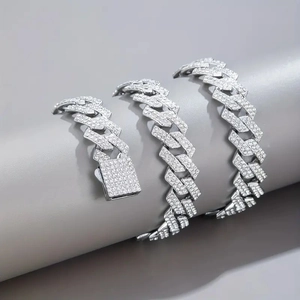 Macro shot of high-density pavé set moissanite stones on a silver cuban link chain