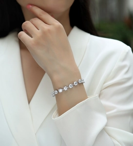 Nahaufnahme des S925 Silber Moissanit Tennis-Armbands an einem Modell in weißem Satin