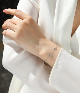 Close-up of S925 silver moissanite bubble bracelet worn with a white suit jacket