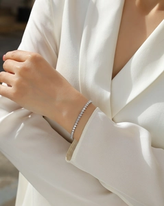Elegantes Silber Tennisarmband mit runden Moissanit-Steinen am Handgelenk eines Modells