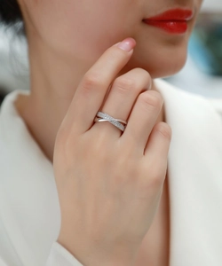 Detail of cross band silver ring with sparkling pave stones on model's finger