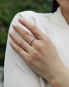 Vista dettagliata di un anello a onda in argento S925 con moissanite indossato sul dito