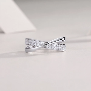 Minimalist 925 silver crossover ring featuring a polished band and shimmering pavé stones