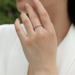 Elegante anello ondulato in argento S925 con pietre moissanite su una mano femminile