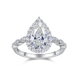 Macro detail of pear cut moissanite ring with halo setting and twisted pave band