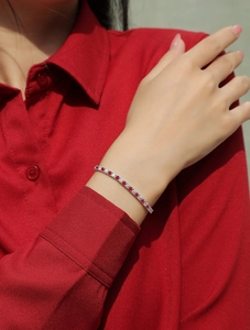 Detail eines Tennisarmbands mit roten und weißen Edelsteinen auf S925 Silber