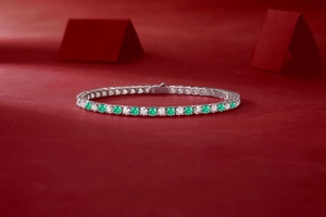 Detaillierte Makroansicht des S925-Stempels und smaragdgrüner Steine auf dem Tennisarmband