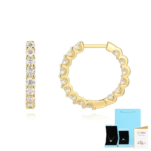 Gros plan de créoles en moissanite dorées avec certificat GRA et coffrets à bijoux