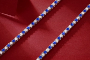 Makroaufnahme eines silbernen Tennisarmbands mit blauen und klaren runden Edelsteinen