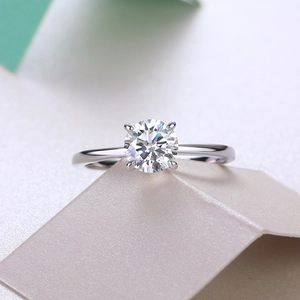 Macro shot of a brilliant round solitaire lab diamond in a classic four-prong silver setting