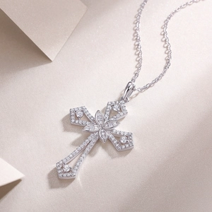 Détail macro du pendentif croix en argent S925 avec diamants moissanite sur fond champagne