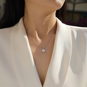 Close-up of elegant 925 silver necklace with round moissanite pendant on model