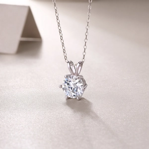 Close-up of elegant six-prong moissanite pendant on a silver box chain necklace
