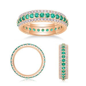 Close-up of a three-row rose gold ring with emerald green and clear stones