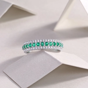Macro detail of S925 silver ring band with 11 round emerald green gemstones and diamonds