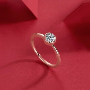 Primo piano dell'anello in moissanite oro rosa S925 con punzonatura su sfondo rosso
