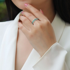 Close-up of S925 silver ring with three-row pavé green and white gemstones on a model