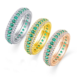 Eternity ring set in silver, gold, and rose gold with green gemstones and white diamonds