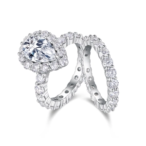 Close-up of a pear-cut moissanite ring set with a matching diamond eternity band