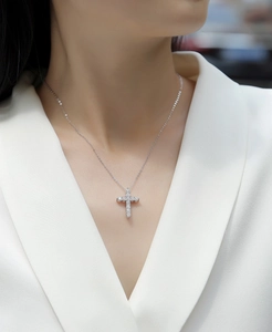 Close-up of lab-grown diamond cross pendant on S925 silver chain worn by a model