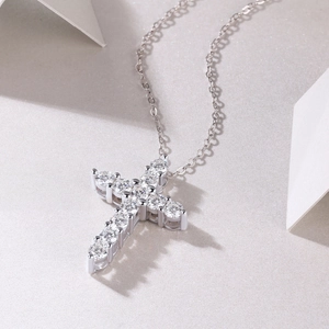 Macro shot of a silver cross pendant with sparkling pave diamonds and o-chain necklace
