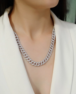 Close-up of a silver S925 Cuban link necklace with full pavé moissanite on a white suit