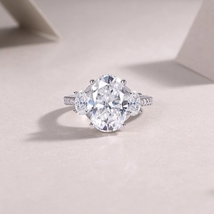 Λεπτομέρεια macro δαχτυλιδιού με οβάλ moissanite, σχέδιο τριών λίθων και pavé διαμάντια