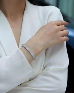 Detail view of a sparkling S925 sterling silver bangle set with moissanite on a model