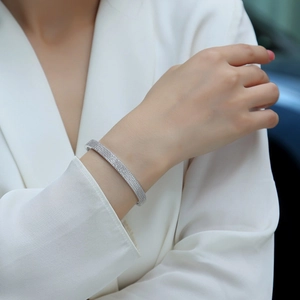 Elegantly paved moissanite bangle in S925 silver on model in minimalist white suit