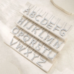 Makroaufnahme von 26 Buchstaben-Halsketten aus S925 Silber mit funkelnden Moissanit-Steinen