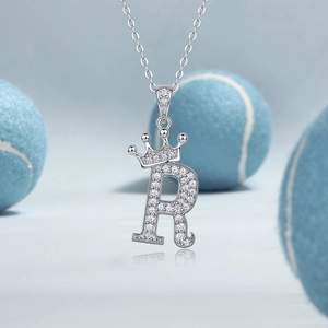 Macro detail van zilveren S925 ketting met letter R hanger, kroon en zirkonia inleg