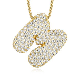 Detail of gold bubble letter K pendant with pave-set zircons on a golden box chain
