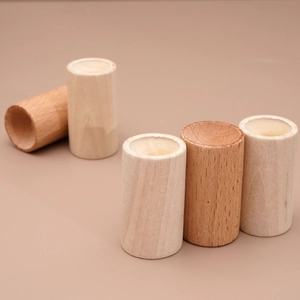 Close-up of cylindrical wood essential oil diffusers in natural and dark walnut finishes