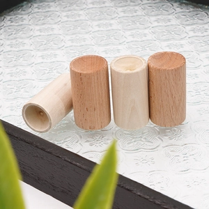 Close-up of four cylindrical solid wood essential oil diffusers with natural grain details