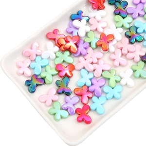 Close-up of colorful acrylic butterfly beads in a white tray for DIY jewelry making