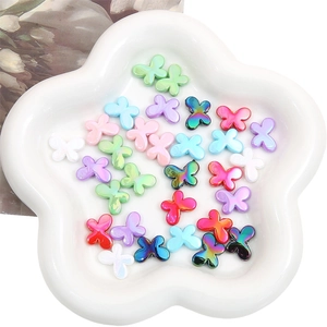 Macro shot of colorful acrylic butterfly beads for DIY jewelry making on white tray