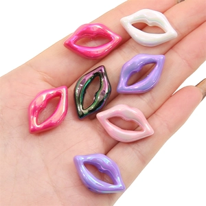 Hand holding colorful acrylic mabe lip beads for DIY jewelry and bracelets