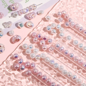 Perle barocche in ABS iridescenti e perle rotonde su vassoio in vetro rosa a onde